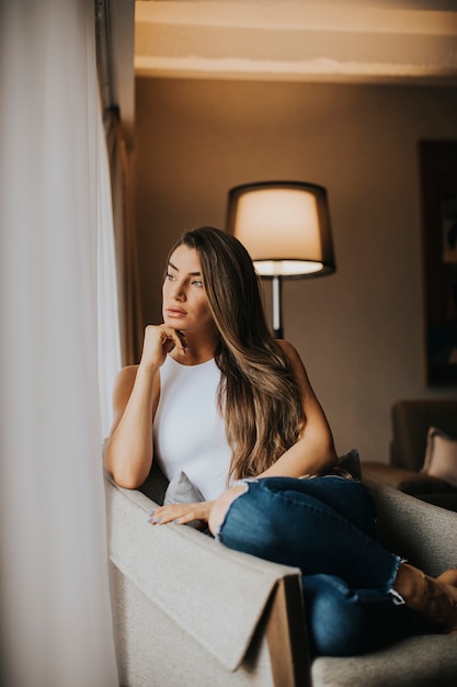 Beautiful young woman sitting by the window