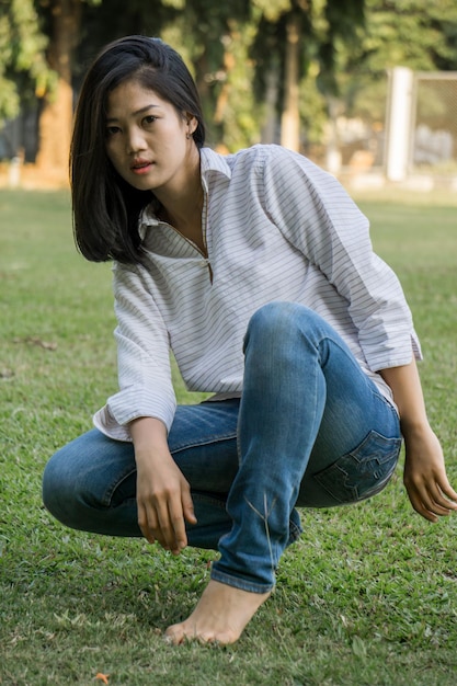 Photo beautiful young woman sitting on field