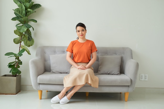 Photo beautiful young woman sitting on sofa, indoors