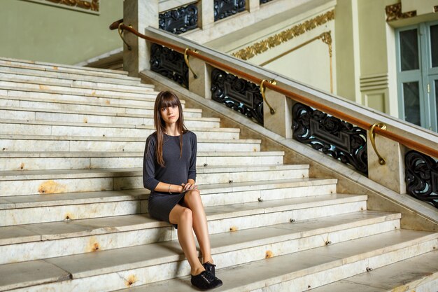 beautiful young woman sitting on the steps