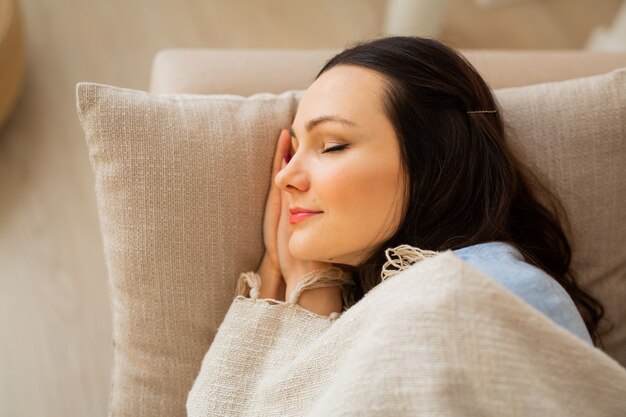 beautiful young woman sleeping on the sofa under a blanket