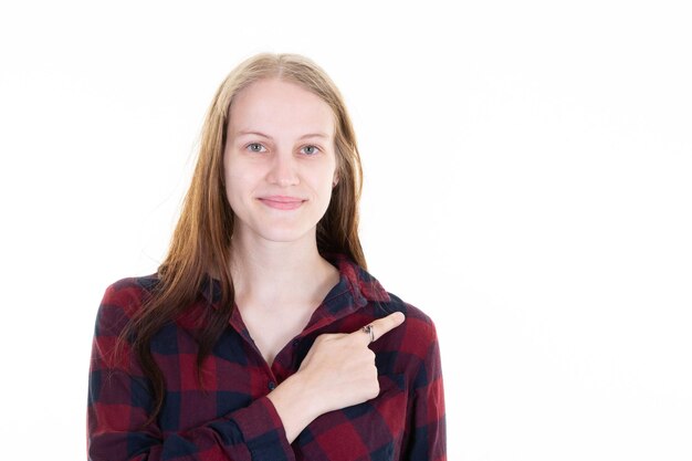 Beautiful young woman smile happy and pointing finger side copy space blank white background