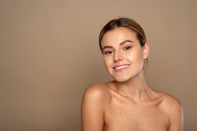 Photo beautiful young woman smiling after fantastic face treatment. happy beauty lady excited after spa treatment isolated on background with copy space.
