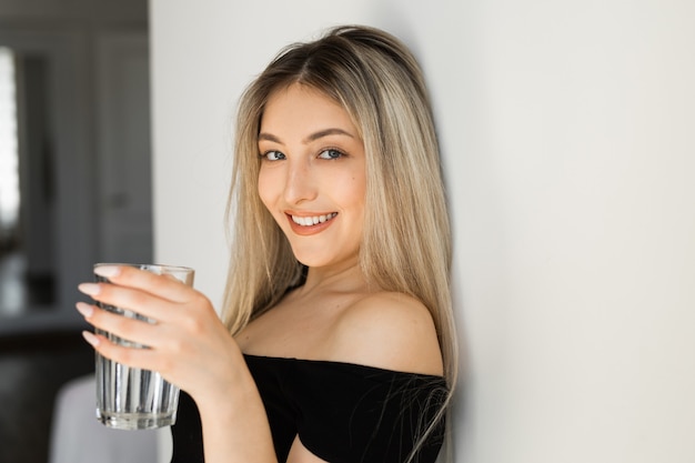 beautiful young woman in sportswear with a glass of water