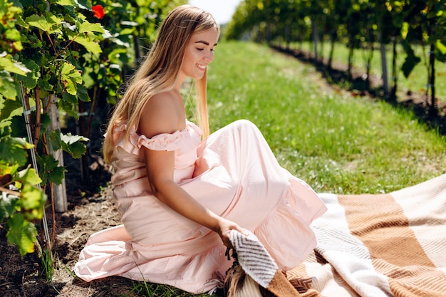 Beautiful young woman spreads out plaid for picnic