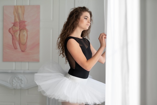 Beautiful young woman standing against wall at home