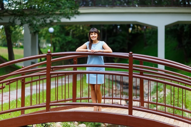 Beautiful young woman standing on the bridge