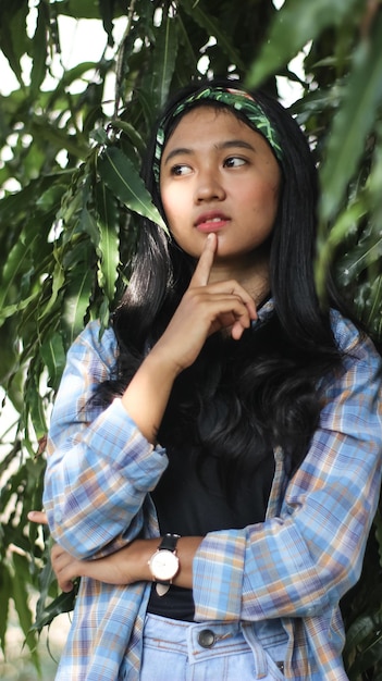 Photo beautiful young woman standing by tree