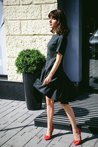 Photo beautiful young woman standing on footpath in city