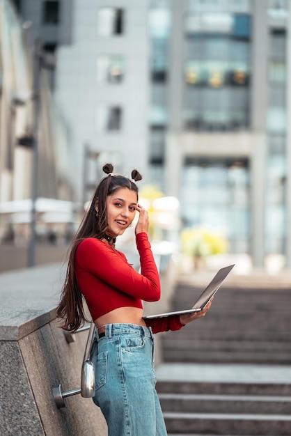 Beautiful young woman on the street using laptop