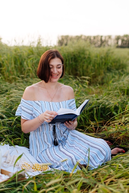 Foto bella giovane donna in estate in un campo di grano