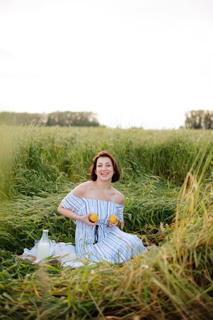 Foto bella giovane donna in estate in un campo di grano