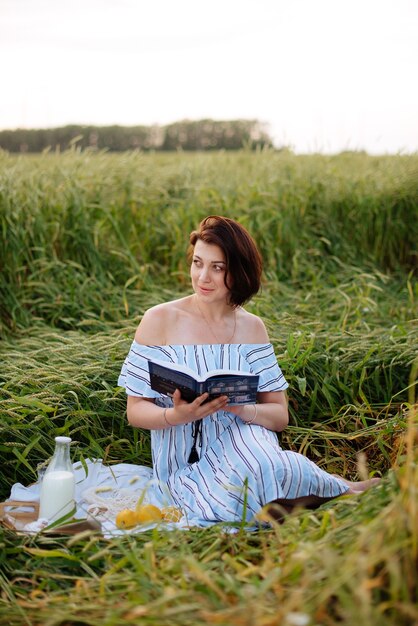 Beautiful young woman in summer in a wheat field