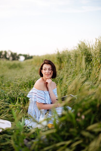 麦畑で夏の美しい若い女性