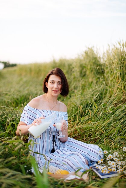 Beautiful young woman in summer in a wheat field