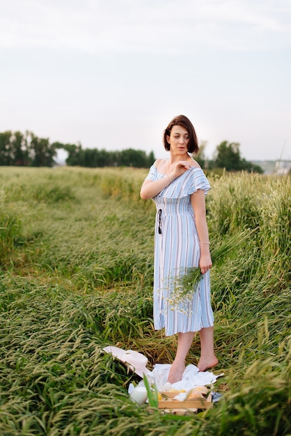 Beautiful young woman in summer in a wheat field