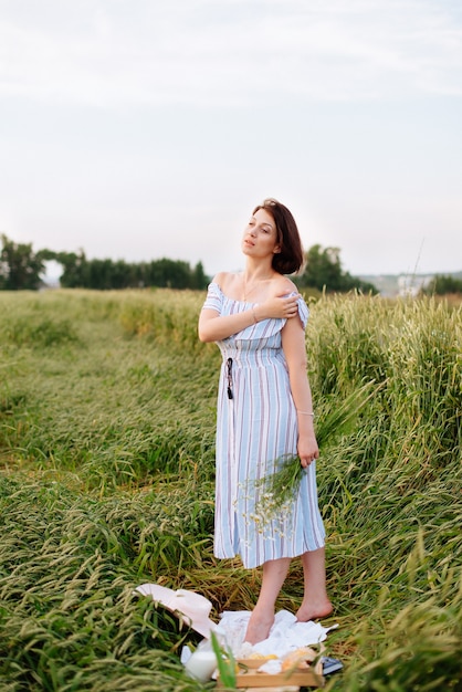 麦畑で夏の美しい若い女性