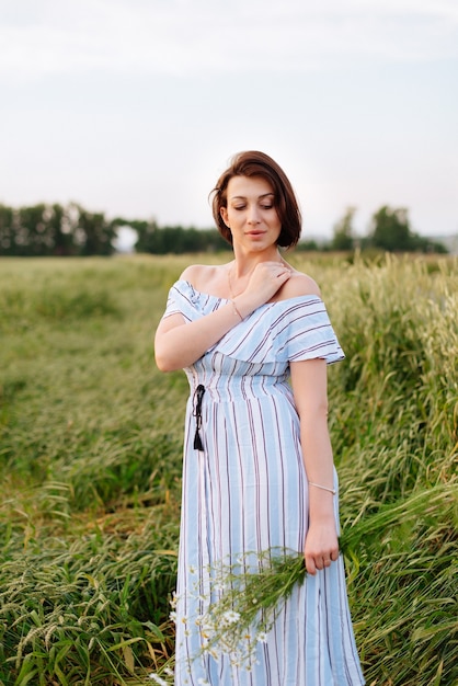 Beautiful young woman in summer in a wheat field