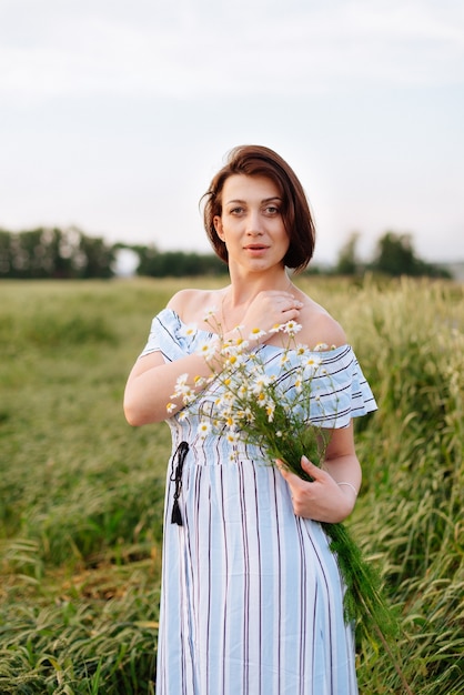 麦畑で夏の美しい若い女性