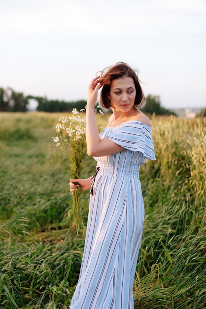 Beautiful young woman in summer in a wheat field