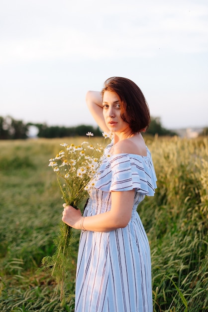 Beautiful young woman in summer in a wheat field