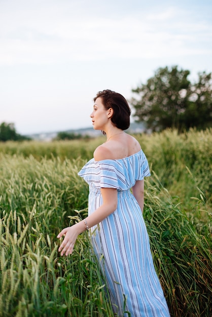 麦畑で夏の美しい若い女性