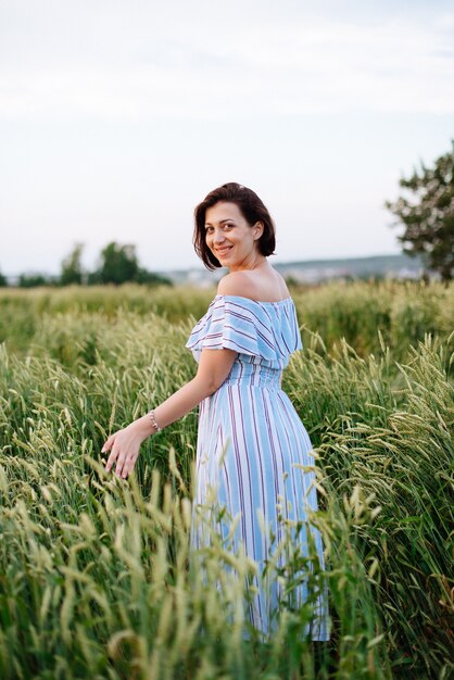 Beautiful young woman in summer in a wheat field