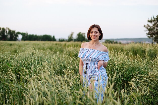 Beautiful young woman in summer in a wheat field