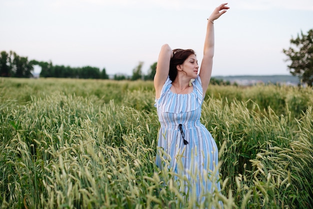 麦畑で夏の美しい若い女性