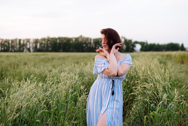 Beautiful young woman in summer in a wheat field