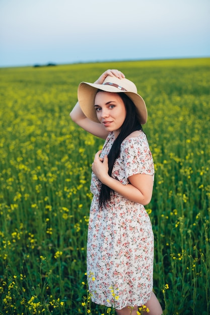 Beautiful young woman at sunset in the field