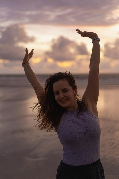 Beautiful young woman at sunset on the ocean, Bali, Indonesia.