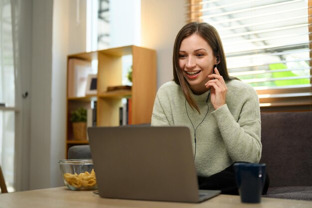 Beautiful young woman surfing internet shopping online on laptop at home