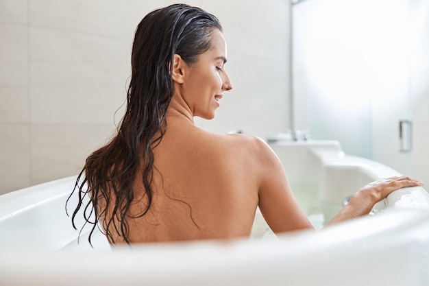 Foto bella giovane donna che fa il bagno a casa