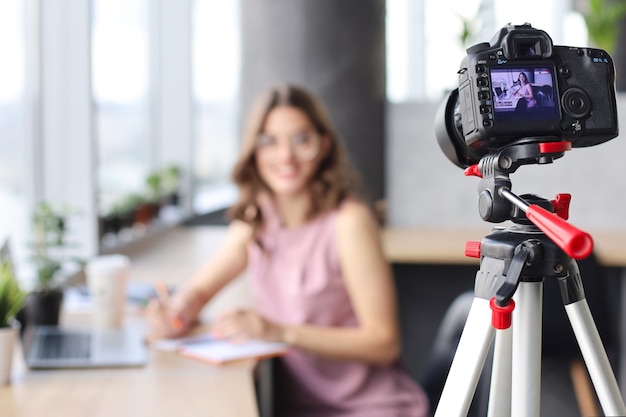 Beautiful young woman talking and smiling while making new video for her blog.