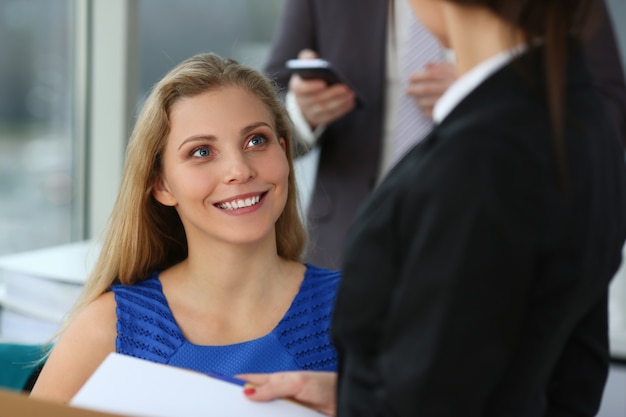 Photo beautiful young woman talking with colleagues at work