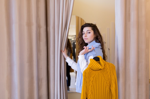 beautiful young woman trying on clothes bought in a fitting shop