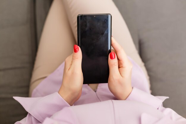 beautiful young woman using an application to send an sms message in her smartphone device while eating a salad