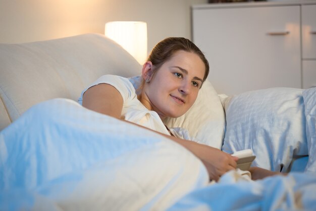 Photo beautiful young woman using digital tablet in bed at night