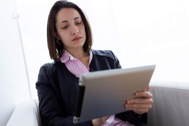 아름 다운 젊은 여자는 사무실에서 그녀의 디지털 태블릿을 사용 하여.
