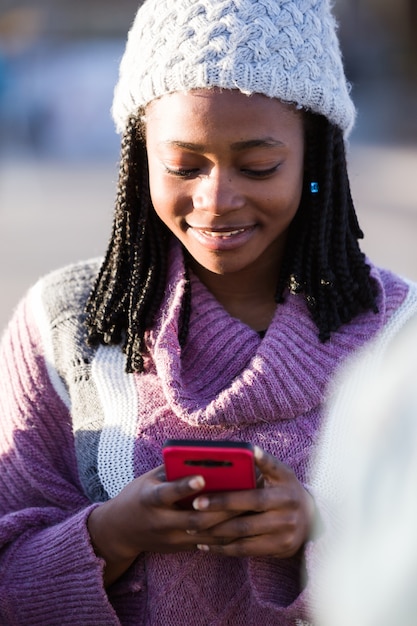 Foto bella giovane donna che usando il suo telefono cellulare in strada.