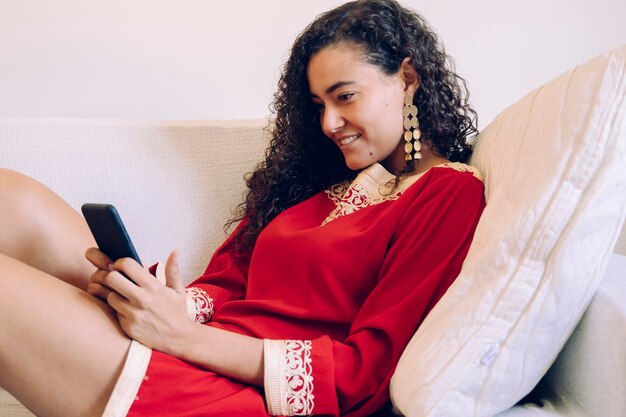 Beautiful young woman using a smartphone at home