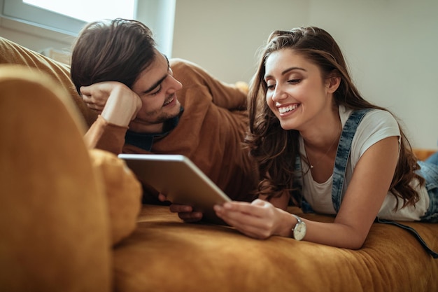 彼女のボーイフレンドとタブレットを使用して美しい若い女性