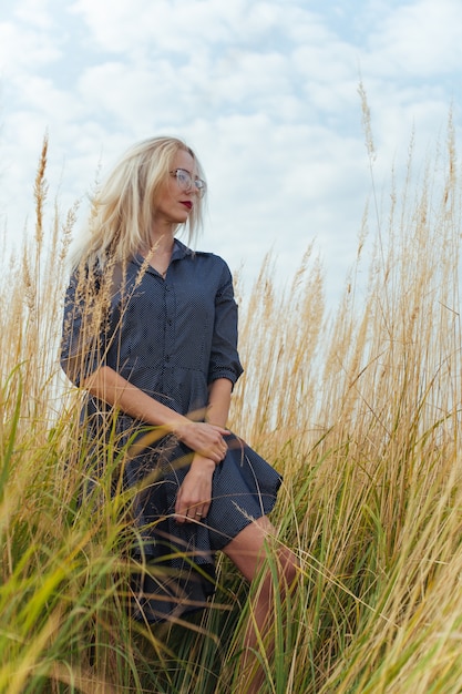 Beautiful young woman villager posing in a dress in the field