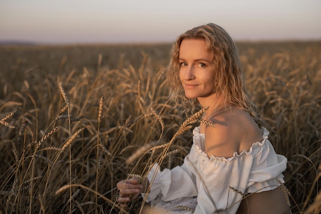 Foto bella giovane donna in una passeggiata in un campo estivo