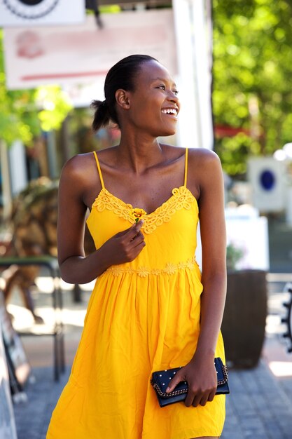 Beautiful young woman walking outdoors with a flower  