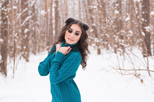 Beautiful young woman walking in the winter snowy nature