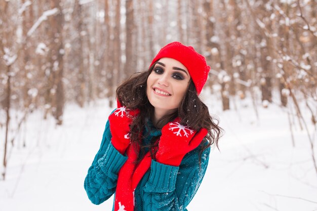 Beautiful young woman walking in the winter snowy nature