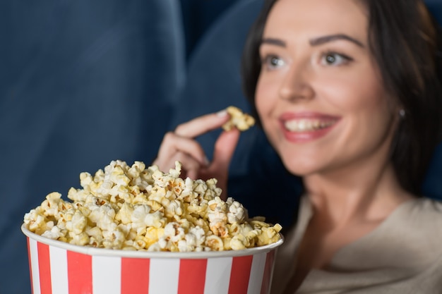 Beautiful young woman watching a film at the movie theatre 