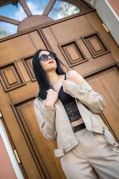 Beautiful young woman wear fashion white suit against old wooden door